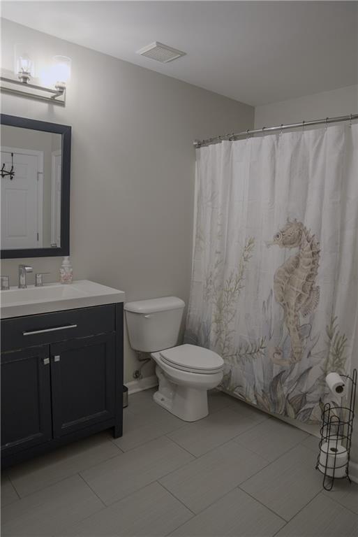 6985 Shane Ln, Cumming, GA 30028 - bathroom with toilet, vanity, and curtained shower