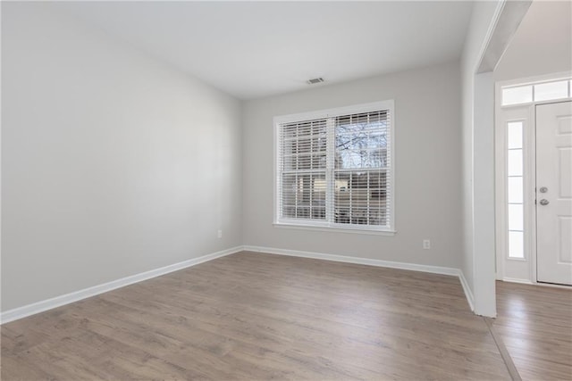 foyer entrance with light wood-type flooring, baseboards, and a wealth of natural light