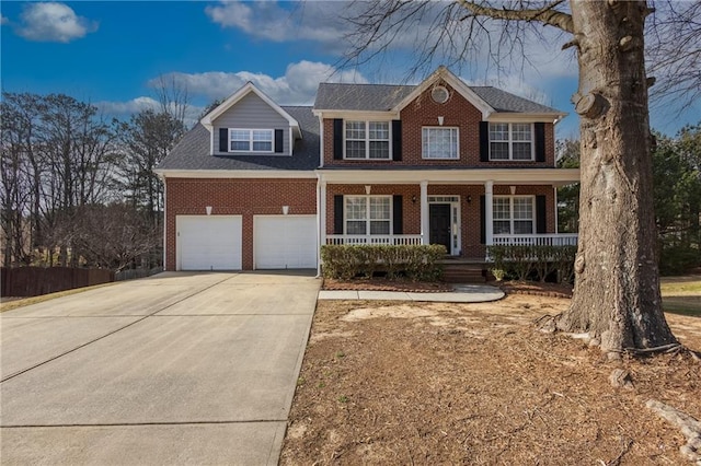 colonial home featuring a garage, a porch, concrete driveway, and brick siding