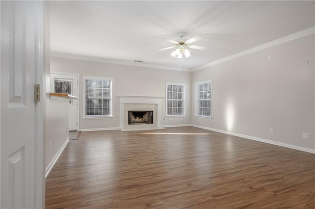 unfurnished living room with dark wood-style floors, a fireplace with raised hearth, ornamental molding, and ceiling fan