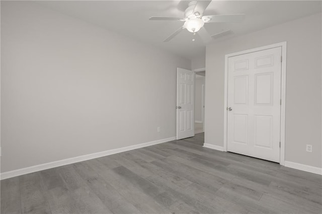 unfurnished bedroom with ceiling fan, baseboards, and wood finished floors