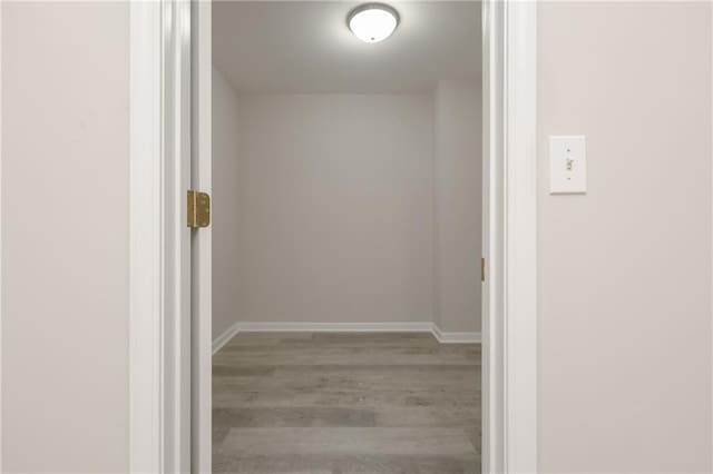 hallway with baseboards and wood finished floors