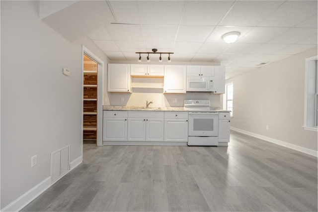 kitchen featuring visible vents, light wood-style flooring, white cabinets, a sink, and white appliances