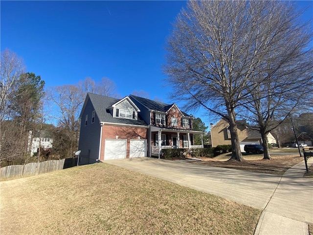 traditional home with a garage, driveway, brick siding, and fence