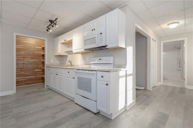 kitchen featuring light countertops, white appliances, a drop ceiling, and light wood-style flooring