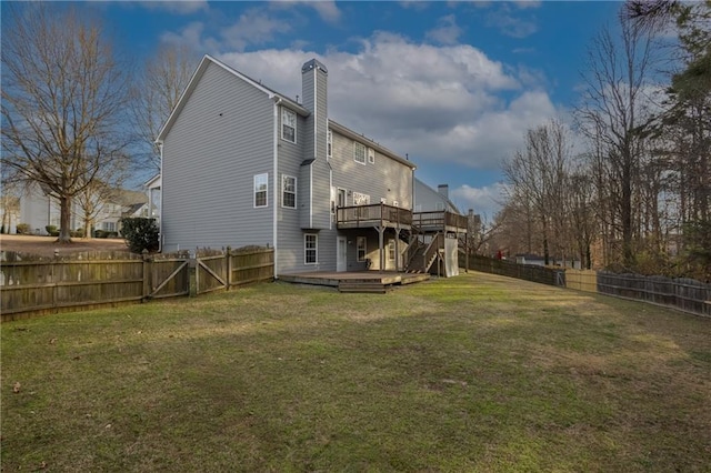 rear view of property featuring a deck, a yard, a chimney, and a fenced backyard