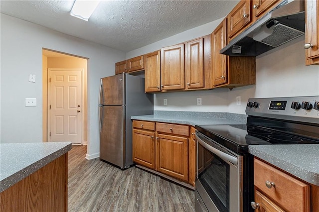 kitchen with hardwood / wood-style floors, stainless steel appliances, and a textured ceiling