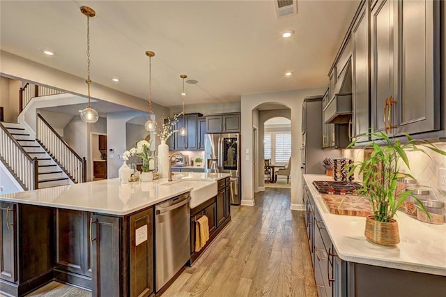 13 Clearwater Ct, Hoschton, GA 30548 - kitchen featuring stainless steel appliances, arched walkways, a sink, light countertops, and recessed lighting