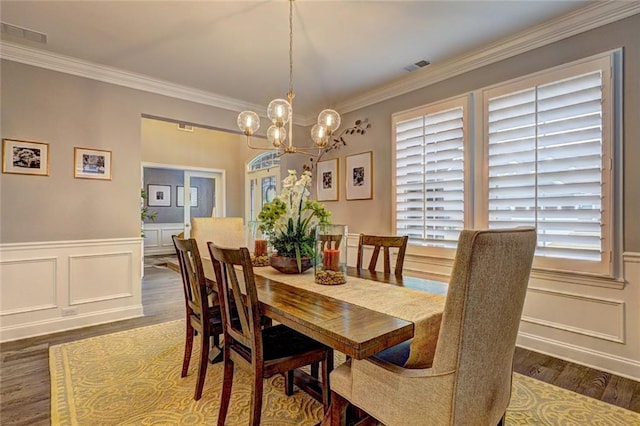 13 Clearwater Ct, Hoschton, GA 30548 - dining room featuring a chandelier, crown molding, wood finished floors, a decorative wall, and wainscoting