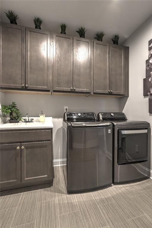 13 Clearwater Ct, Hoschton, GA 30548 - laundry area featuring independent washer and dryer, cabinet space, and baseboards