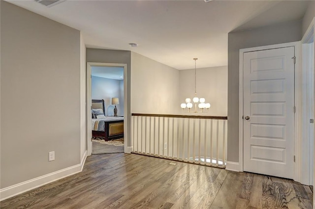 13 Clearwater Ct, Hoschton, GA 30548 - unfurnished room with wood finished floors, a chandelier, and baseboards
