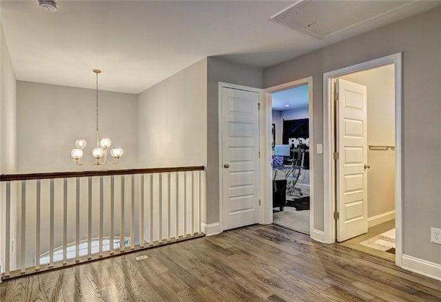 13 Clearwater Ct, Hoschton, GA 30548 - spare room with wood finished floors, baseboards, a chandelier, a smoke detector, and attic access