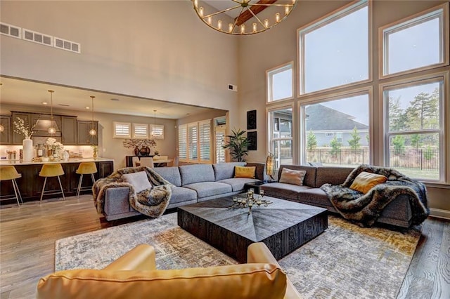 13 Clearwater Ct, Hoschton, GA 30548 - living area with light wood finished floors, a chandelier, and a towering ceiling