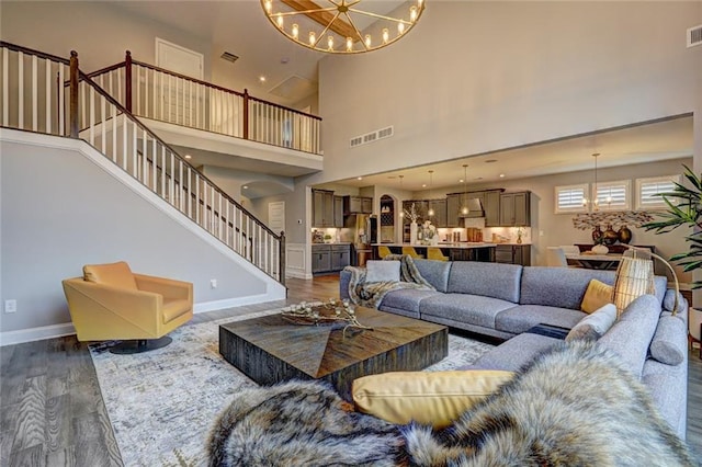 13 Clearwater Ct, Hoschton, GA 30548 - living room featuring a chandelier, stairway, dark wood-style flooring, baseboards, and a high ceiling