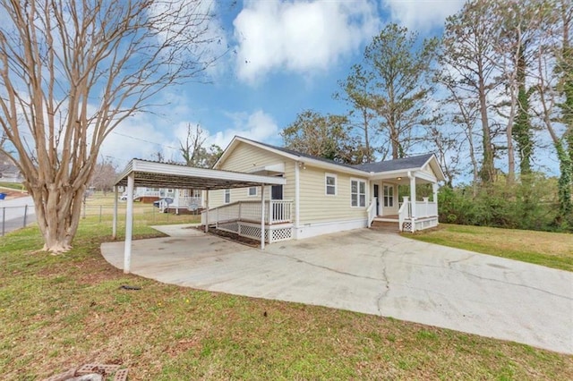 view of home's exterior featuring a lawn, covered porch, concrete driveway, and fence