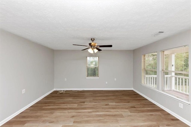 unfurnished room with visible vents, baseboards, light wood-type flooring, and a ceiling fan