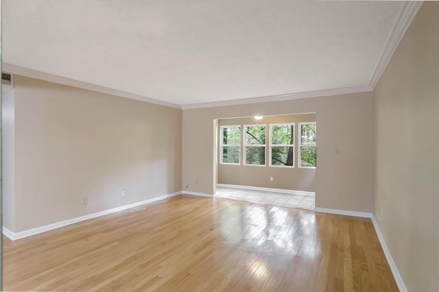 spare room featuring light hardwood / wood-style floors and ornamental molding