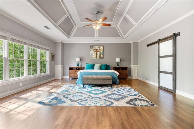 3578 Hope Rd, Cumming, GA 30041 - bedroom featuring baseboards, ornamental molding, a barn door, visible vents, and wood finished floors