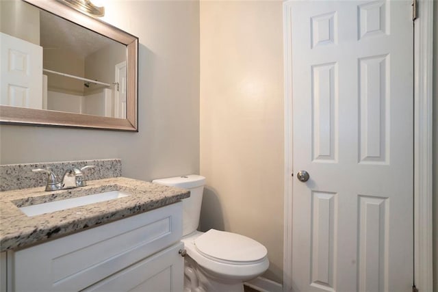 bathroom featuring vanity, toilet, and walk in shower