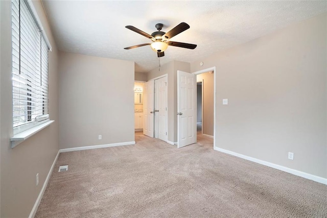 unfurnished bedroom featuring light carpet and ceiling fan