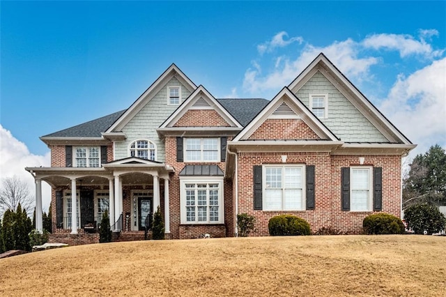 craftsman inspired home featuring covered porch and a front yard