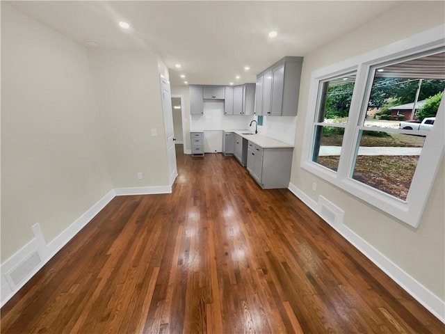 1955 S Columbia Pl, Decatur, GA 30032 - kitchen with gray cabinetry, dark wood-type flooring, baseboards, recessed lighting, and a sink