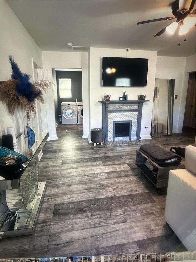 1132 SE Oak Knoll Ter SE, Atlanta, GA 30315 - living area with washing machine and dryer, a ceiling fan, a tiled fireplace, wood finished floors, and baseboards
