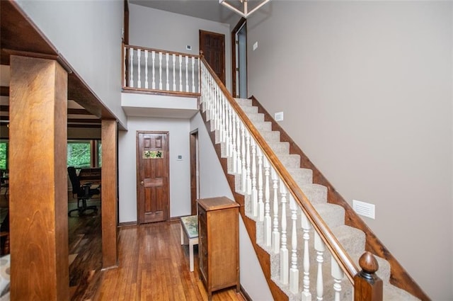 3187 Oak Grove Church Rd, Carrollton, GA 30117 - staircase featuring wood finished floors, a towering ceiling, and baseboards