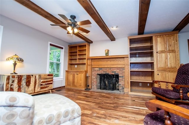 3187 Oak Grove Church Rd, Carrollton, GA 30117 - living room featuring wood finished floors, ceiling fan, beam ceiling, and a brick fireplace