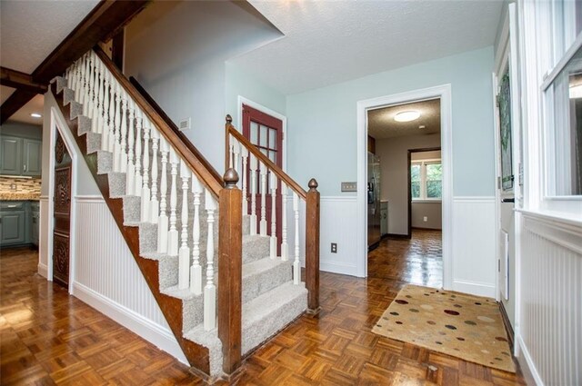 3187 Oak Grove Church Rd, Carrollton, GA 30117 - stairs featuring a wainscoted wall and a textured ceiling