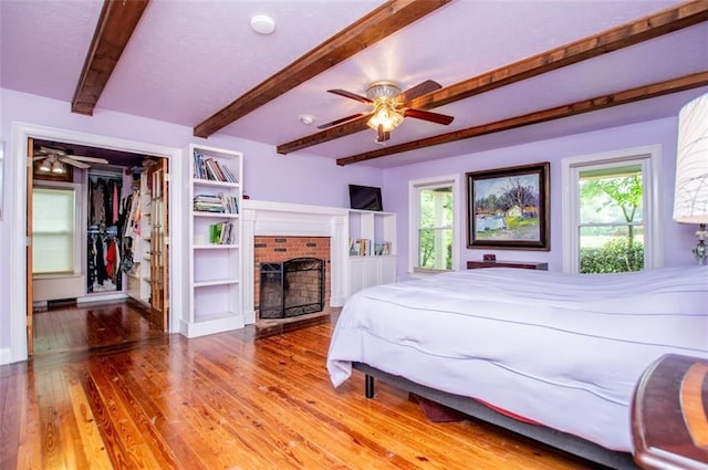 3187 Oak Grove Church Rd, Carrollton, GA 30117 - bedroom featuring beam ceiling, wood finished floors, a brick fireplace, a walk in closet, and a closet