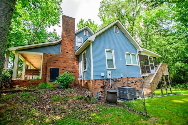 3187 Oak Grove Church Rd, Carrollton, GA 30117 - rear view of property with a sunroom, a chimney, brick siding, a lawn, and stairs