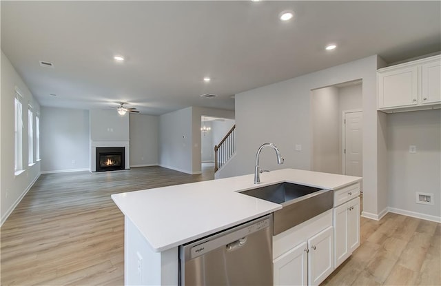 kitchen with light wood-type flooring, white cabinets, a sink, dishwasher, and a ceiling fan