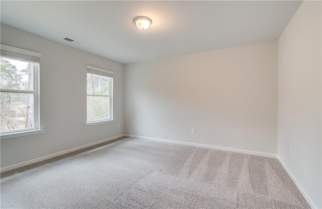carpeted spare room with baseboards and visible vents