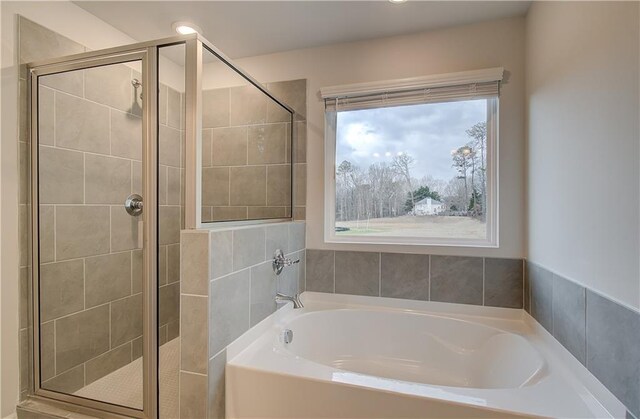 bathroom featuring a stall shower and a garden tub