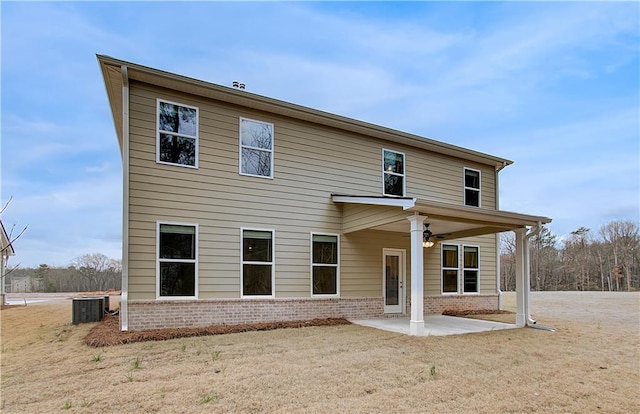 back of house with ceiling fan, a patio area, brick siding, and central AC