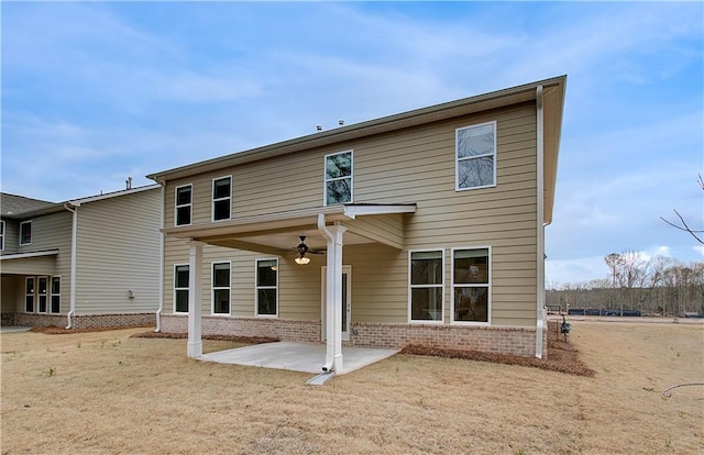 rear view of house featuring brick siding, ceiling fan, and a patio area