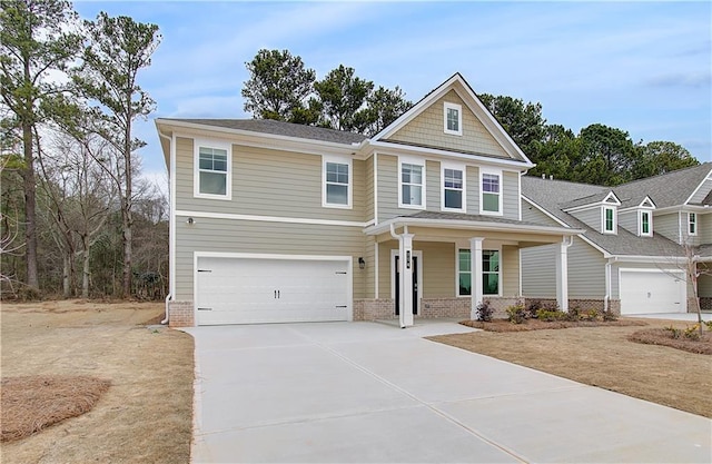 craftsman-style house featuring covered porch, a garage, brick siding, and concrete driveway