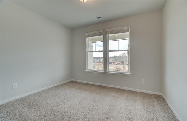 carpeted empty room featuring baseboards and visible vents