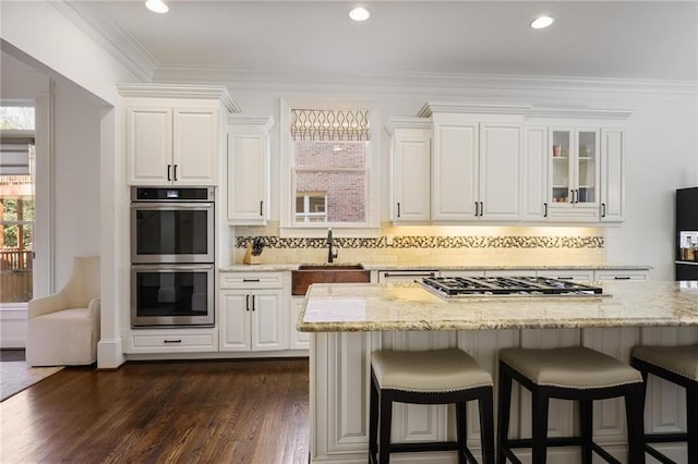 kitchen featuring stainless steel appliances, light stone countertops, sink, and white cabinets