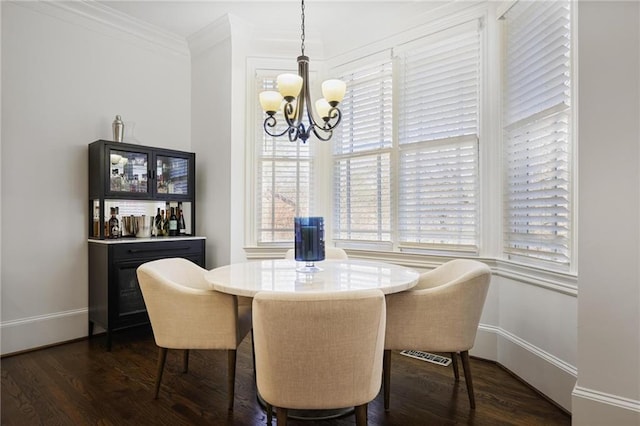 dining space with an inviting chandelier, dark wood-type flooring, and ornamental molding