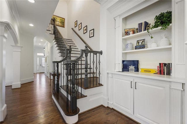 interior space featuring white cabinetry, ornamental molding, dark hardwood / wood-style floors, and decorative columns