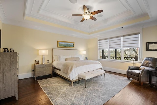 bedroom featuring ornamental molding, dark hardwood / wood-style floors, and a tray ceiling