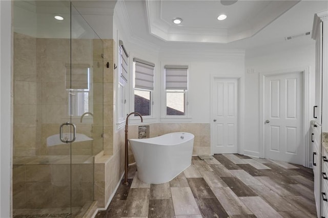 bathroom with tile walls, vanity, ornamental molding, plus walk in shower, and a raised ceiling