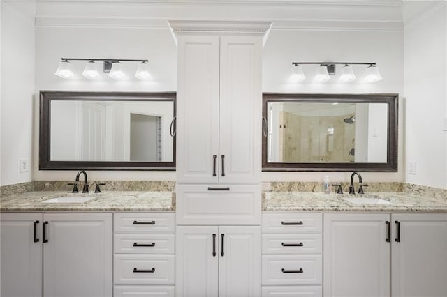 bathroom with vanity, a shower with shower door, and ornamental molding