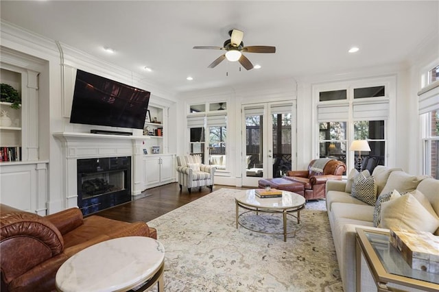 living room with ornamental molding, dark hardwood / wood-style flooring, built in features, and a wealth of natural light