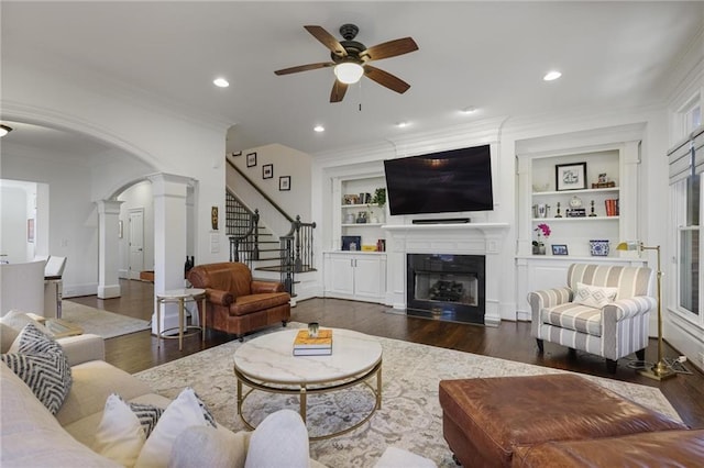 living room with ornate columns, ornamental molding, dark hardwood / wood-style flooring, and built in shelves