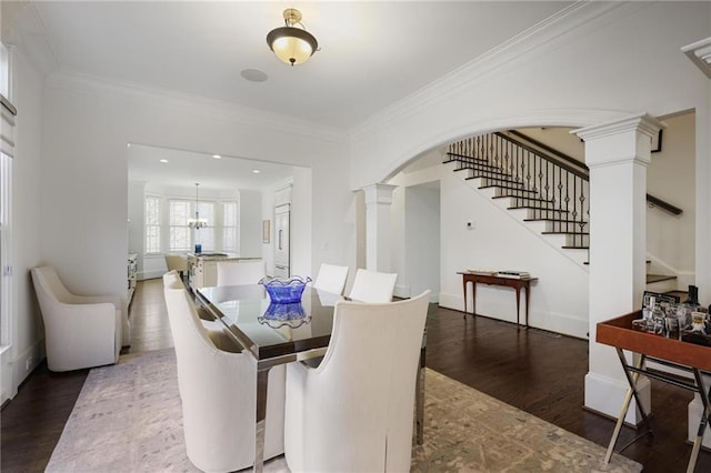 dining space with crown molding, dark hardwood / wood-style floors, and ornate columns