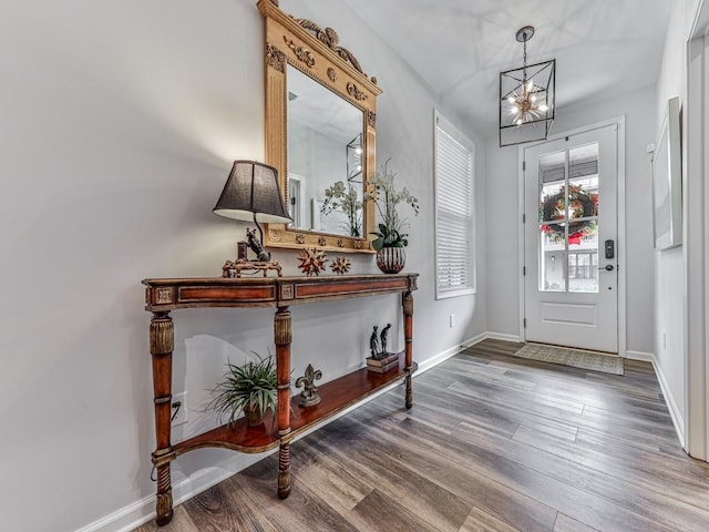 entryway with wood-type flooring and a chandelier