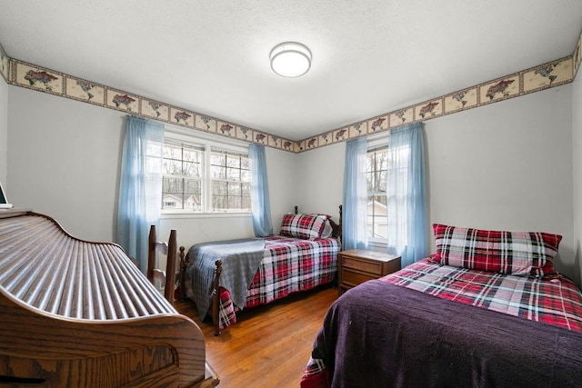 bedroom with hardwood / wood-style floors and a textured ceiling